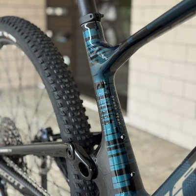 Quadro de bicicleta de montanha azul e preto com pneus cravados e texto SPARK TEAM