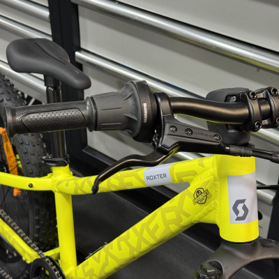 Bicicleta amarela Roxter com componentes Shimano e Tektro, suspension dianteira e selim preto