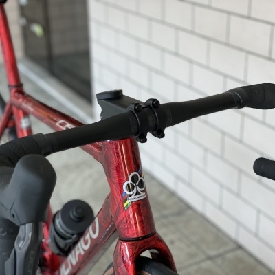 Bicicleta de estrada vermelha metálica com guiador preto e garrafa de água