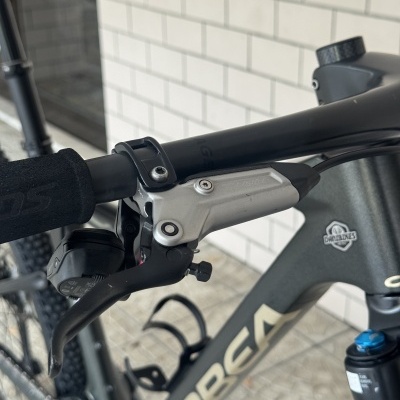 Bicicleta de montanha cinzenta com componentes pretos e logótipos visíveis.
