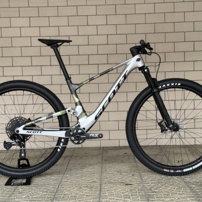 Bicicleta de montanha Scott cinza e branca com rodas Maxxis e suspensão