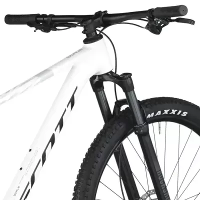 Bicicleta de montanha branca com guiador preto e pneus Maxxis pretos