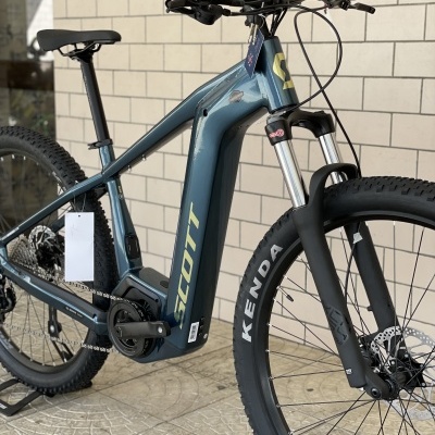 Bicicleta elétrica de montanha azul-acinzentada SCOTT com pneus pretos KENDA