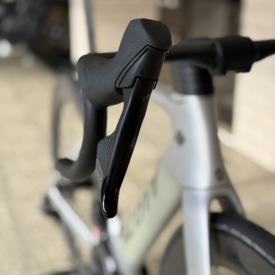 Bicicleta de estrada branca com guiador drop e manípulo SRAM preto