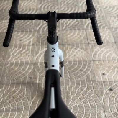 Bicicleta de estrada branca e preta vista de cima com guiador preto e selim