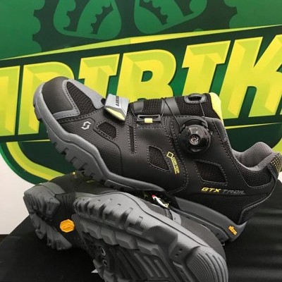 Sapatos de trekking pretos e cinza com detalhes amarelos e solado robusto