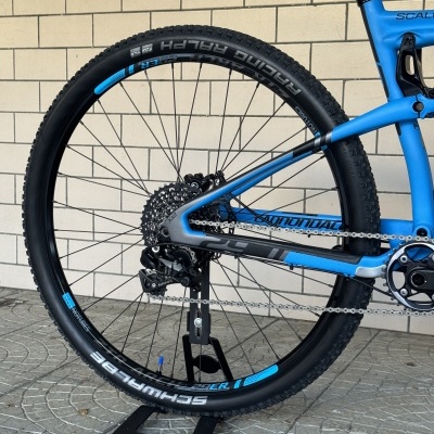 Roda traseira de bicicleta de montanha azul Cannondale com pneus pretos Schwalbe Racing Ralph
