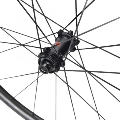 Roda de bicicleta preta com cubo negro e detalhes vermelhos.