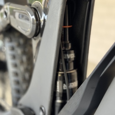 Amortecedor traseiro preto dentro do quadro cinza de uma bicicleta