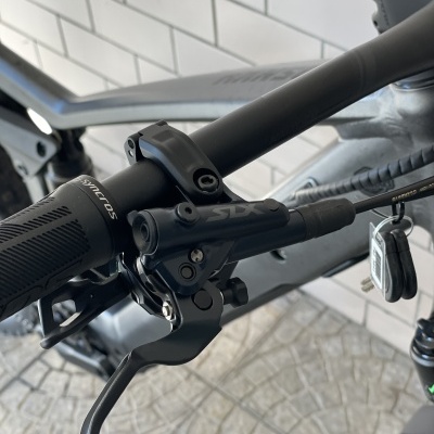 Punho e travão hidráulico de bicicleta negra com inscrições SLX e Syncros