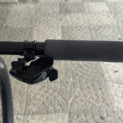Punho de bicicleta preto com manete de mudanças e chão cimentado