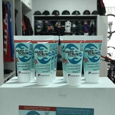 Cinco tubos de creme hidratante para mãos PANACOS15 S.A. exibidos sobre caixa branca em loja de bicicletas.