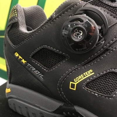 Sapatilha trail preta com sistema BOA, texto GORE-TEX e GTX TRAIL, detalhes em amarelo.