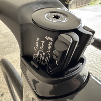 Peça preta de bicicleta com texto e parafuso