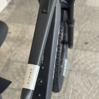 Quadro preto fosco de bicicleta elétrica STRIXE sobre pavimento de mosaico português