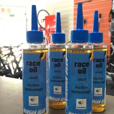 Quatro frascos de óleo de corrida com rótulo azul e tampa azul num balcão