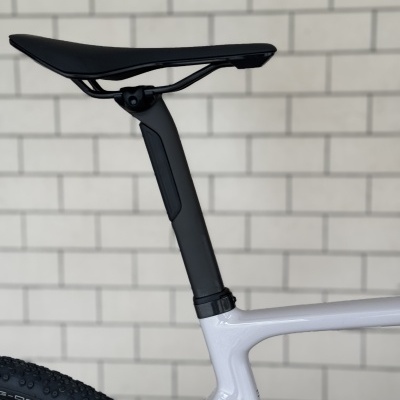 Detalhe traseiro de bicicleta com selim preto e quadro branco