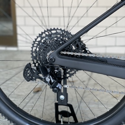 Roda traseira de bicicleta com pneu preto, cassete de engrenagens e corrente