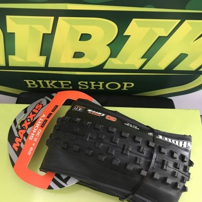 Pneu de bicicleta Maxxis Shorty 29x2.30 preto com embalagem laranja e preto e fundo verde AI BIK BIKE SHOP.