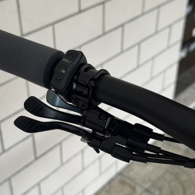 Guiador de bicicleta preto com punho de espuma e controlador de modo com texto WALK e setas