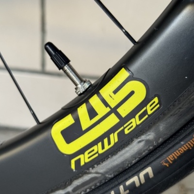 Roda de bicicleta com pneu Continental Ultra Sport e adesivo amarelo newrace