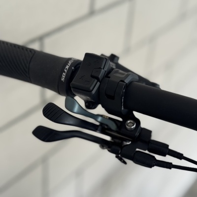 Punho preto de bicicleta com comandos elétricos e texto SANDOS