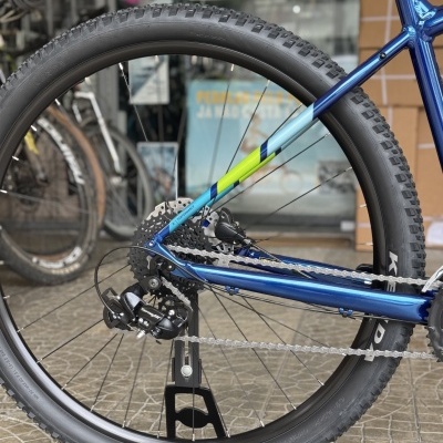 Roda traseira de bicicleta de montanha azul com pneu grosso e sistema Shimano