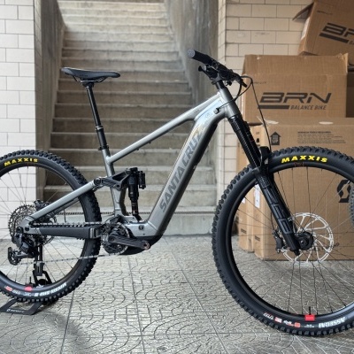Bicicleta elétrica de montanha cinza com suspensão traseira e pneus Maxxis