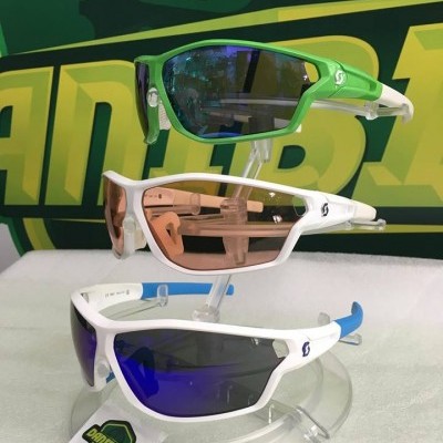 Três óculos de sol desportivos em exposição com lentes espelhadas e armações verde e branco
