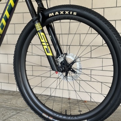 Roda dianteira preta de bicicleta com suspensão RockShox e pneu Maxxis