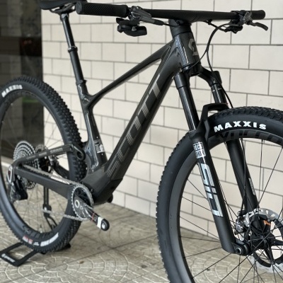 Bicicleta de montanha preta com pneus Maxxis e suspensão RockShox