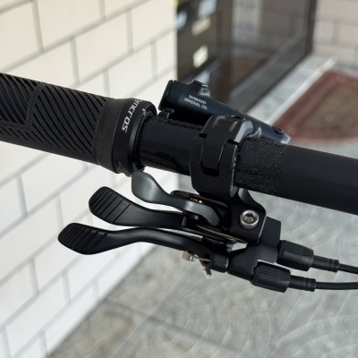 Punho de bicicleta preto com alavancas de mudança e cabo