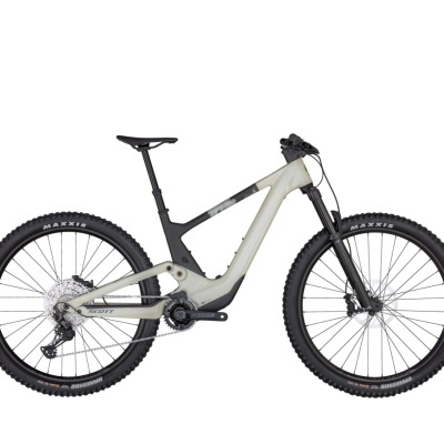Bicicleta elétrica de montanha cinzenta e preta com pneus Maxxis e suspensão dianteira.