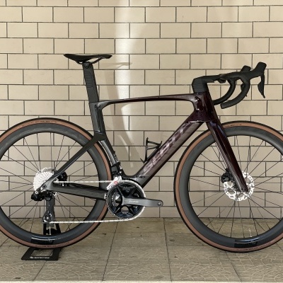 Bicicleta de estrada Trek em carbono preta montada contra parede de azulejos