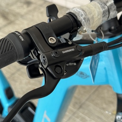 Punho de bicicleta com manete de travão Shimano e guiador preto em bicicleta azul