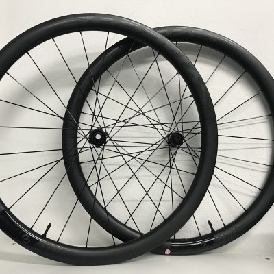 Duas rodas de bicicleta negras apoiadas contra uma parede branca