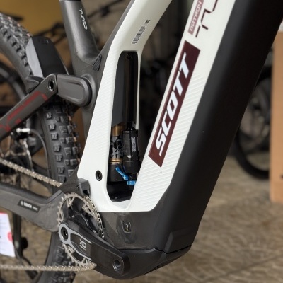 Bicicleta elétrica montanha preta e branca com logo SCOTT e suspensão traseira