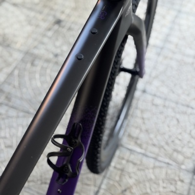 Quadro de bicicleta preto com detalhes roxos e textura nos pneus