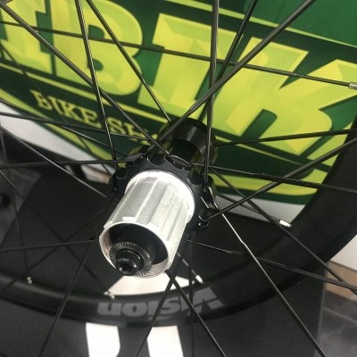 Roda traseira de bicicleta preta com cubo prateado e texto Shimano no aro