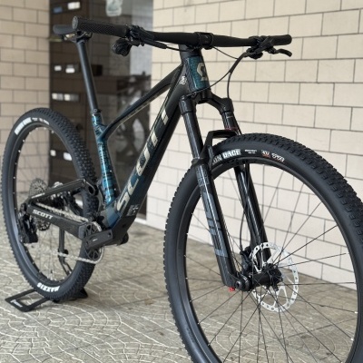Bicicleta de montanha Scott azul escuro e preto com pneus Maxxis e suspensão RockShox