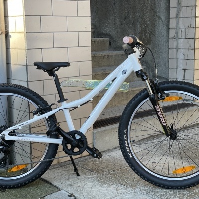 Bicicleta de montanha branca com suspensão dianteira preta e pneus Kenda