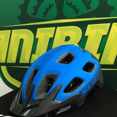 Capacete azul e preto SCOTT com ventilação sobre caixa preta SCOTT