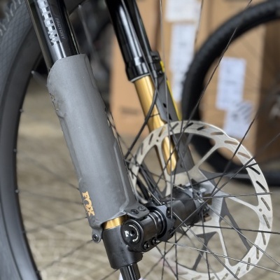 Roda dianteira de bicicleta com suspensão FOX preta e dourada e disco de travão metálico