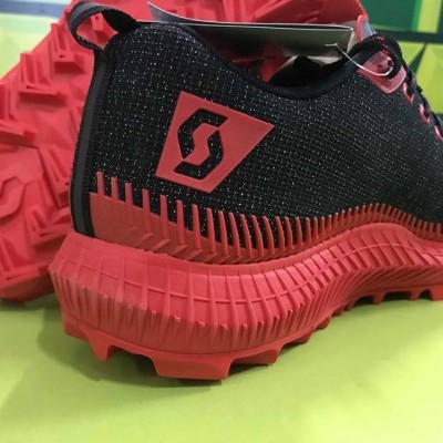 Ténis desportivos pretos e vermelhos com sola texturada