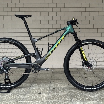 Bicicleta de montanha Scott com quadro verde e preto e pneus Maxxis preta