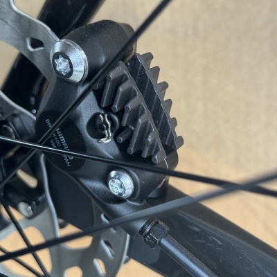 Close-up de componente de travagem de bicicleta preta com disco prateado e raios pretos