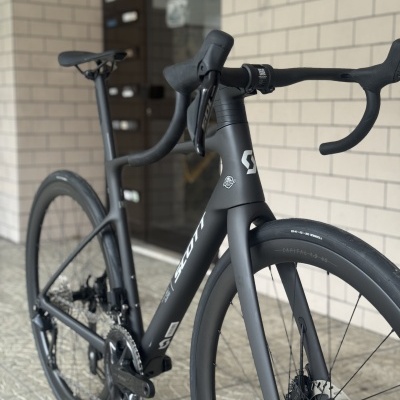 Bicicleta de estrada Scott preta em carbono com pneus finos e travões de disco