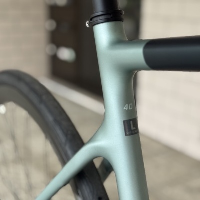 Quadro de bicicleta verde claro com detalhes em preto e etiquetas de tamanho