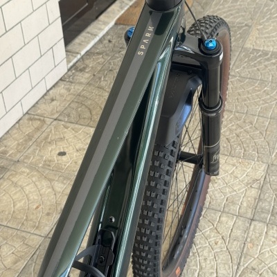 Bicicleta de montanha verde com suspensão dianteira preta e pneus largos