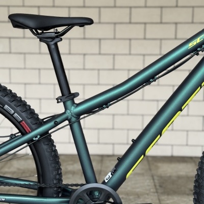 Quadro de bicicleta de montanha verde escuro com selim preto e letras amarelas no tubo diagonal